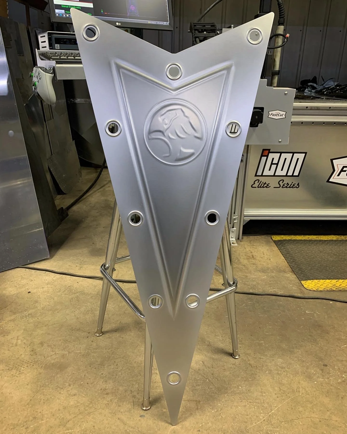 A holden pontiac bead rolled metal logo with a triangular shape and logo in center.