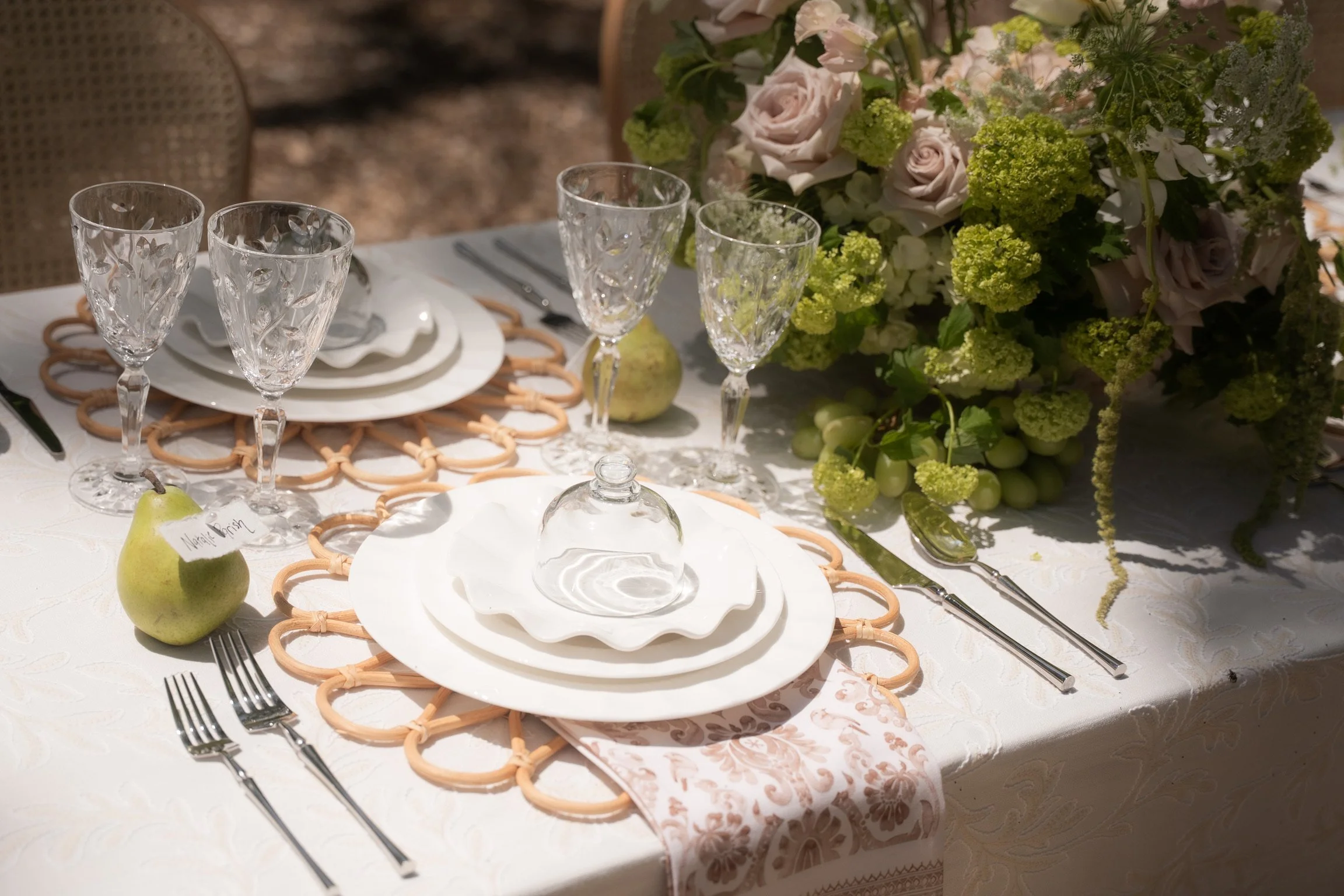 Romantic floral centerpiece paired with elevated wedding tableware rentals.