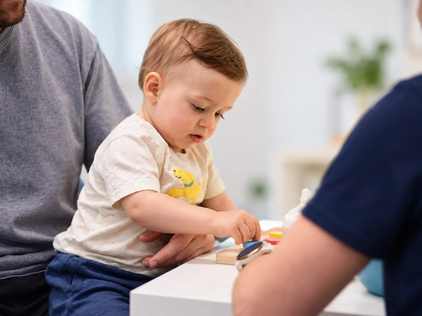 Toddler practising at a table with a therapist