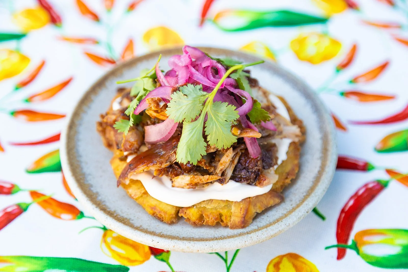 Plantain toston topped with a melody of mushrooms sauteed in Chile Verde Sauce