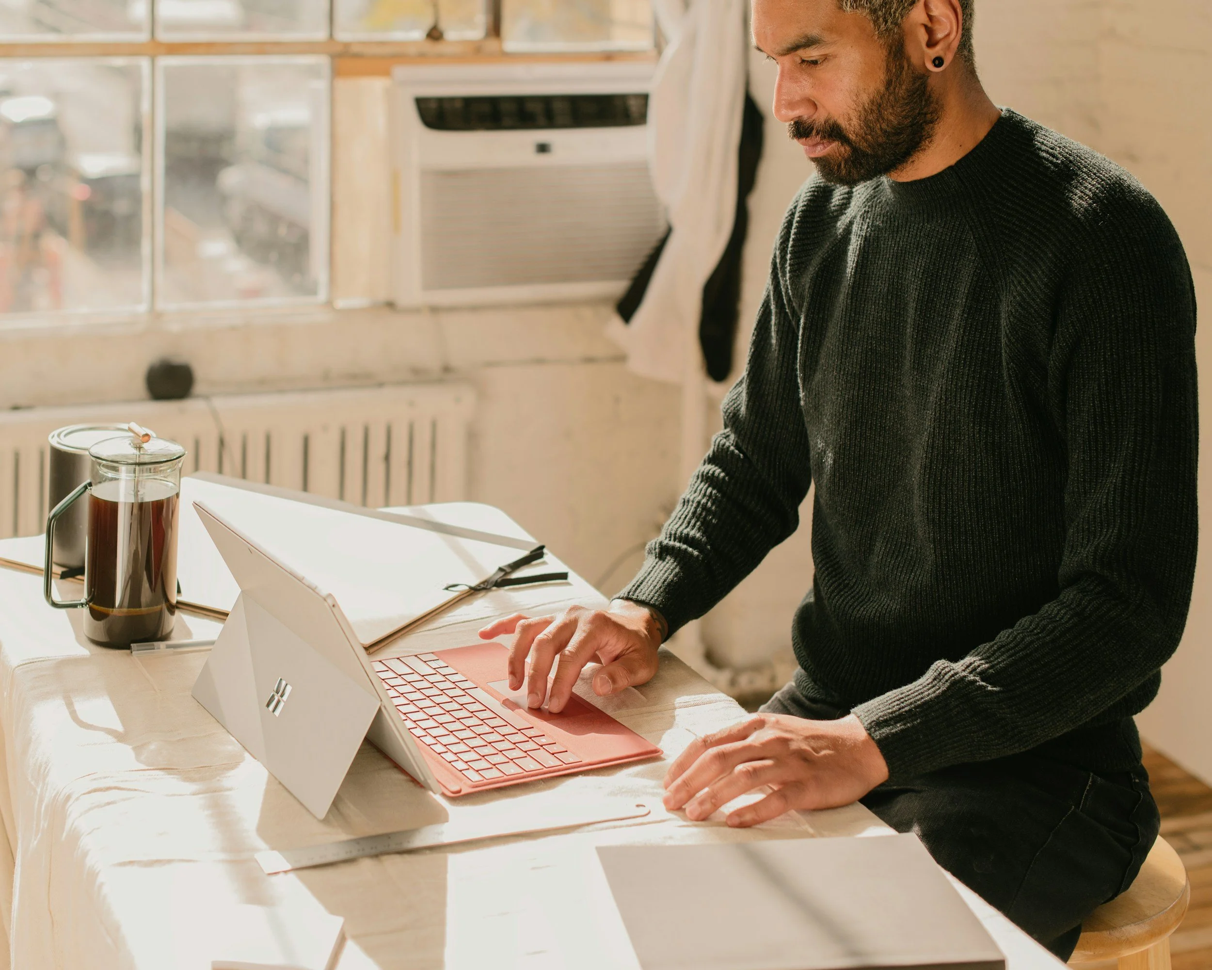 Small business owner working at a desk in a bright home office.