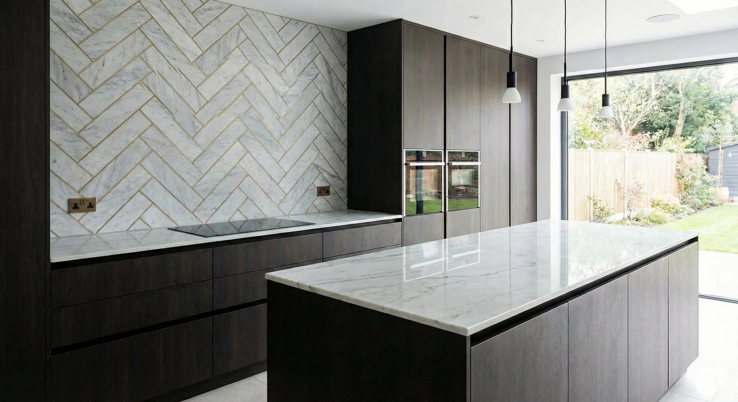Modern kitchen with dark wood cabinets, marble countertops, a marble backsplash in a herringbone pattern, pendant lights, and large glass sliding door leading to a garden.