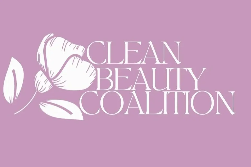 A logo for the Clean Beauty Coalition featuring a stylized white flower on a purple background with the words 'CLEAN BEAUTY COALITION' in elegant white font.