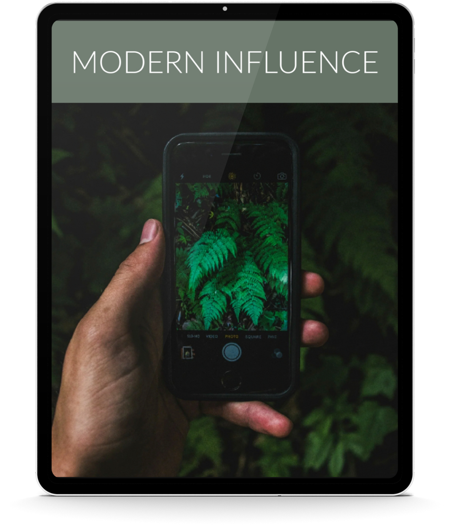 A person holding a smartphone taking a photo of green fern leaves in nature. The phone's screen displays the fern details and camera settings.