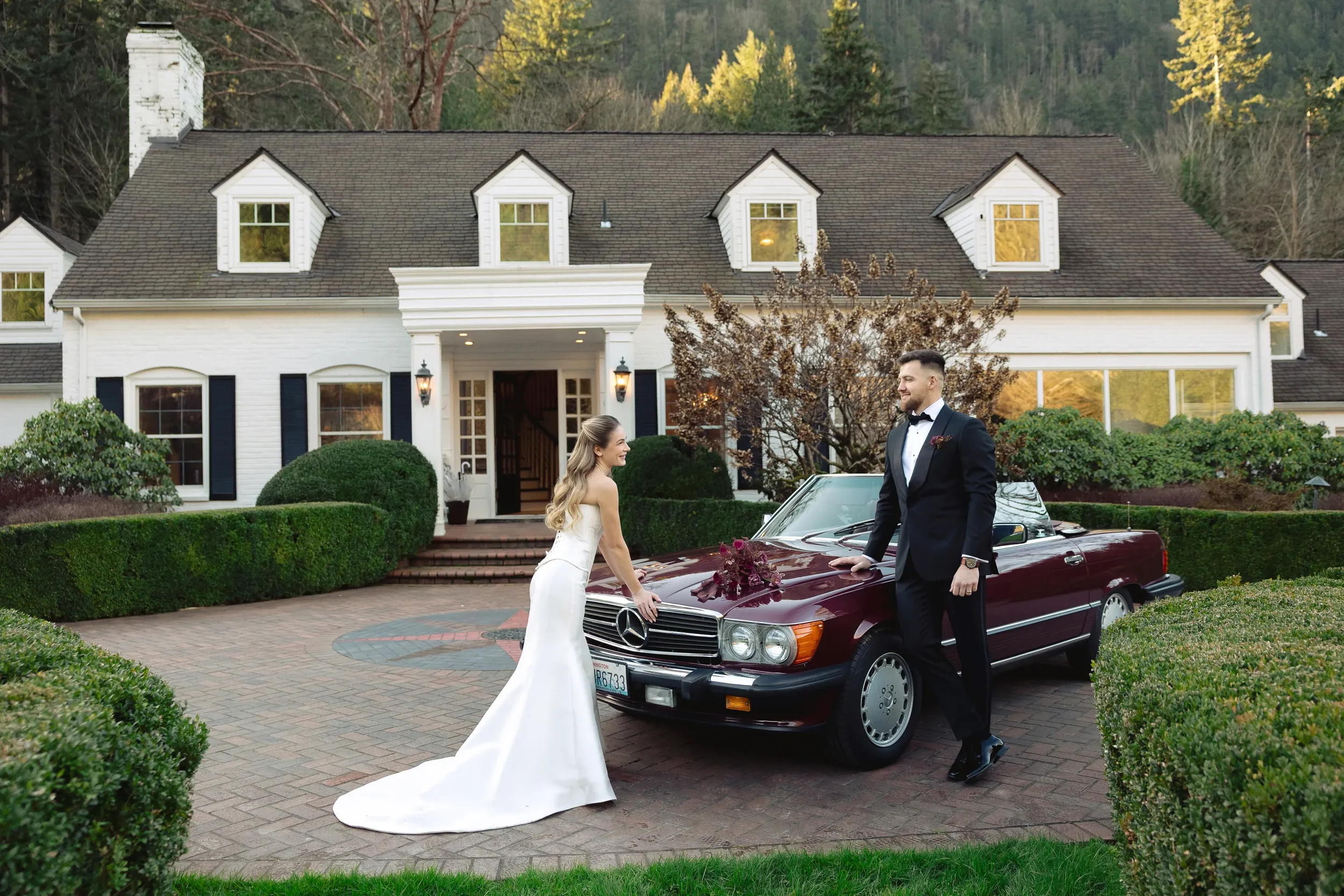 A bride and groom standing beside a vintage convertible in front of the Manor House at Fox Hollow Farm, photographed by a Fox Hollow Farm wedding photographer capturing elegant couples portraits.