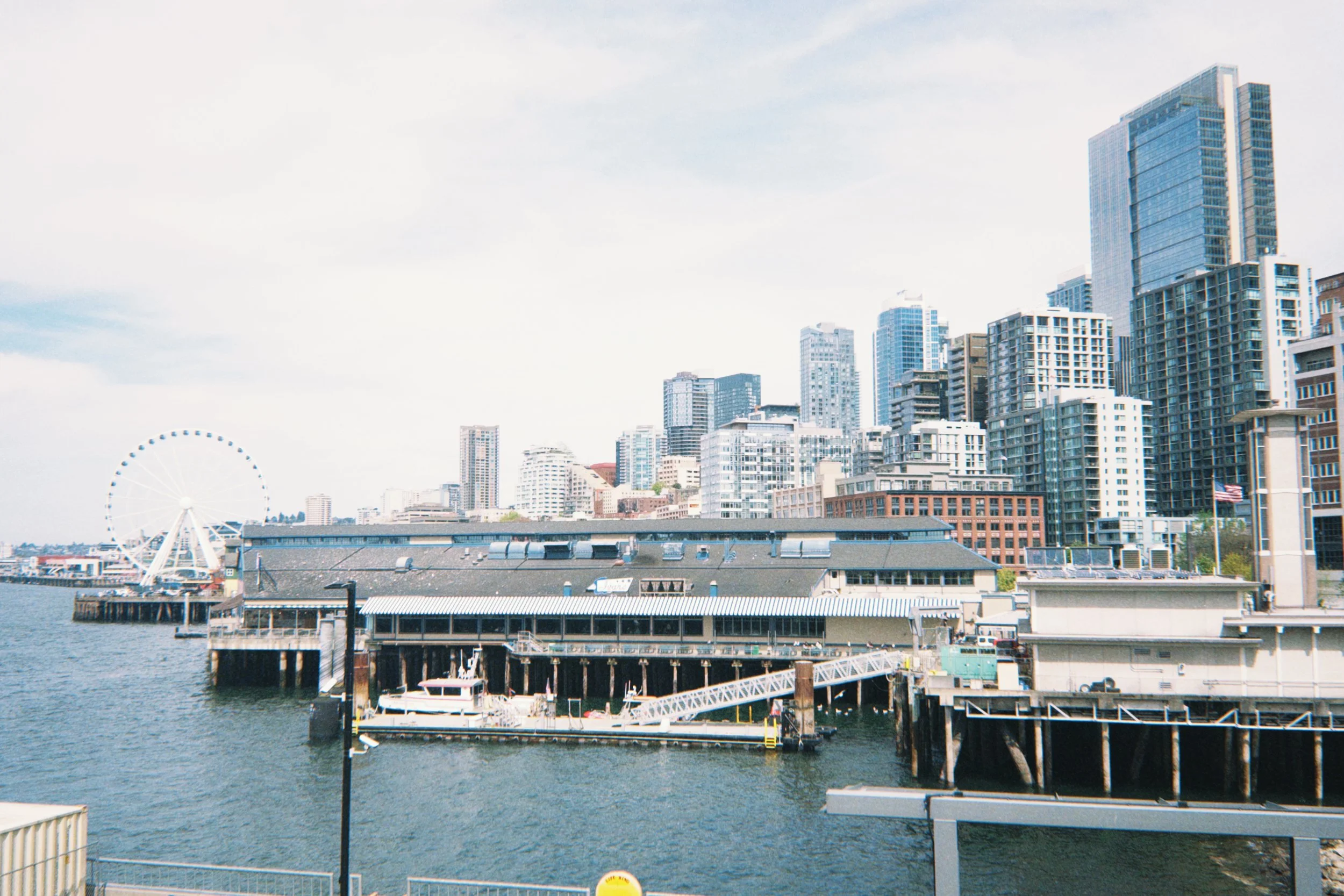 Seattle waterfront skyline with Great Wheel and pier buildings along Elliott Bay