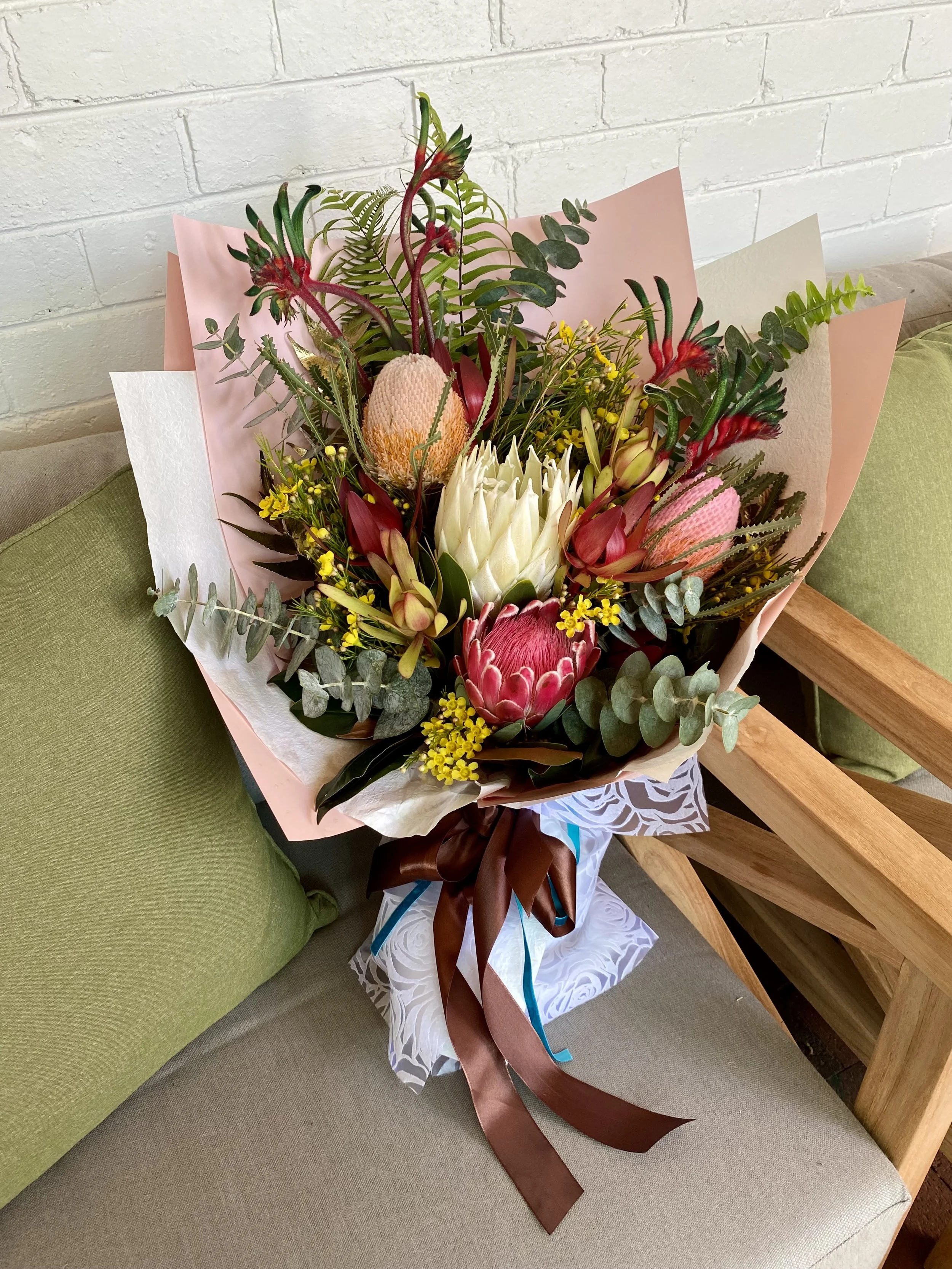 Graduation bouquet featuring Protea, Banksia, Leucadendron, Kangaroo Paw, Geraldton Wax and Eucalyptus. Beautifully wrapped on premium papers and ribbons. Designed and created by Penny Dormer, Wild Heart Flowers. Perth event florist.