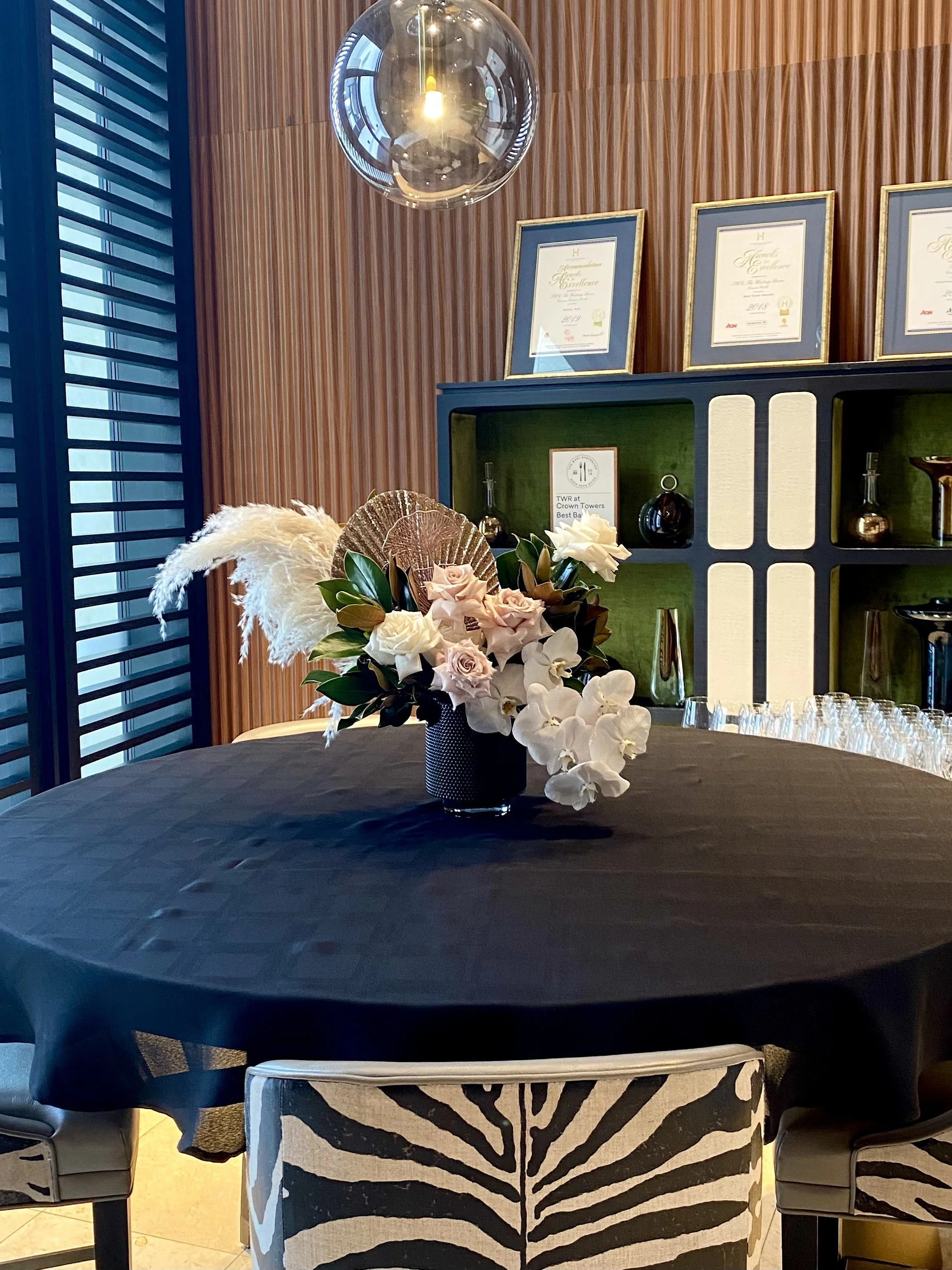Elegant wedding centrepiece in blush pink, white and rose gold with reflexed roses, phalaenopsis orchids, pampas grass, magnolia foliage and rose gold fan palms for an intimate celebration at TWR private lounge Crown Perth, designed by Penny Dormer,