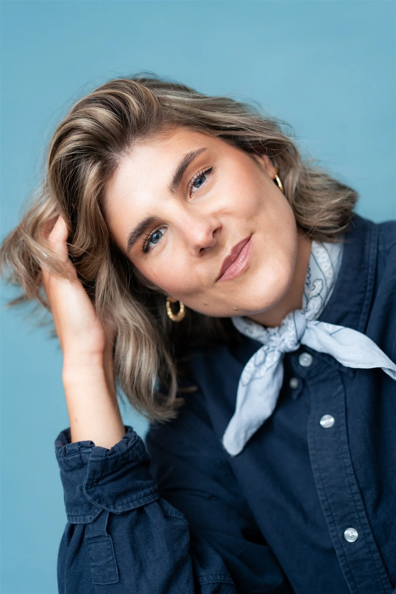 Women with hand in her hair, with blue background