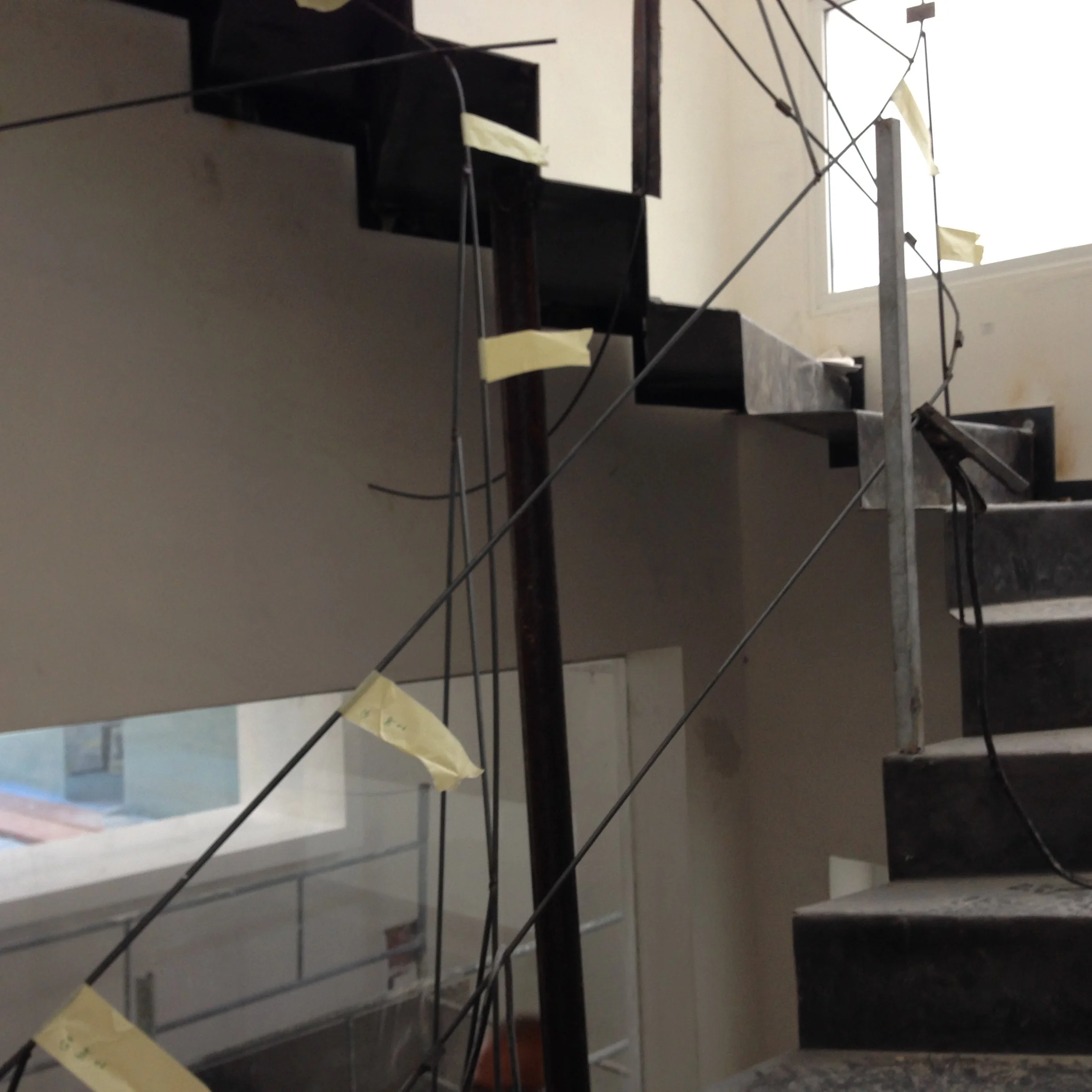 Construction scaffolding with yellow caution tape inside a building near a window.