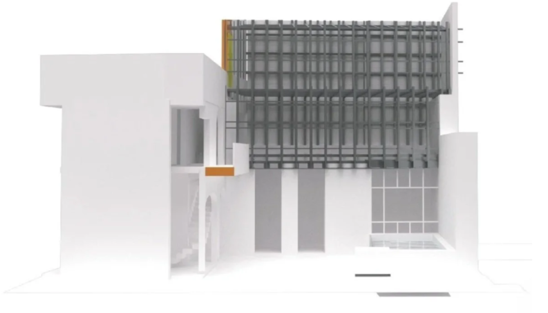 A modern architectural building with a complex facade, featuring white walls, large glass windows, and an overhanging grid-like structure.
