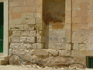 Close-up of weathered stone and brick wall with some crumbling sections