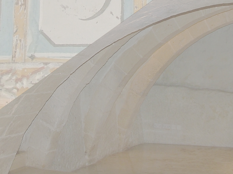 Close-up of a stone or concrete architectural structure with curved arches and detailed craftsmanship.