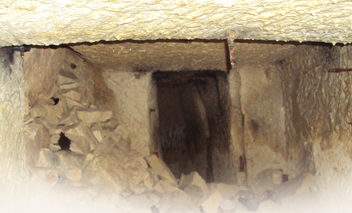 Underground tunnel or passageway with debris and rocks inside.