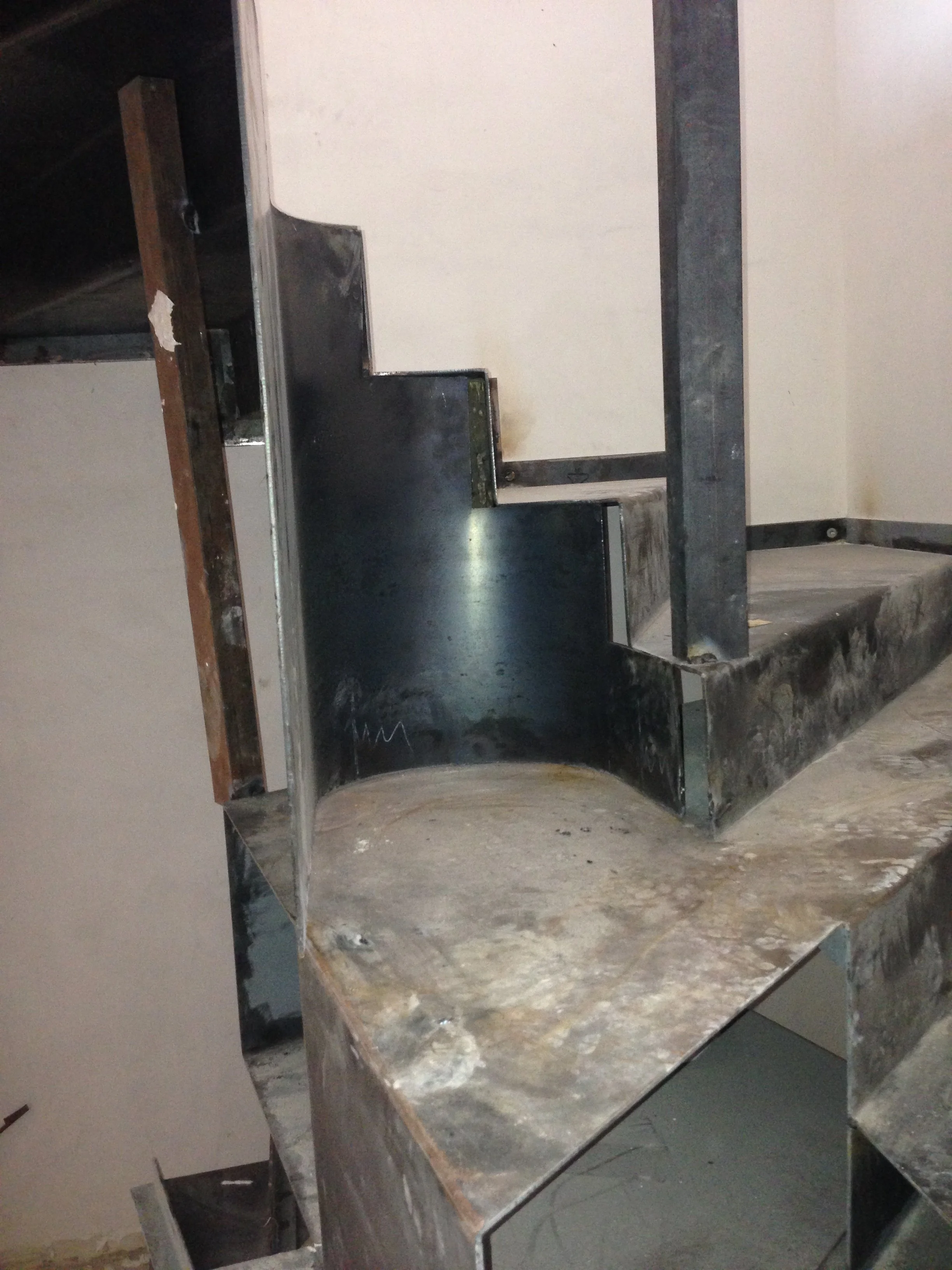 A kitchen countertop under construction with a marble surface and some metal framing, with visible tools and materials around.