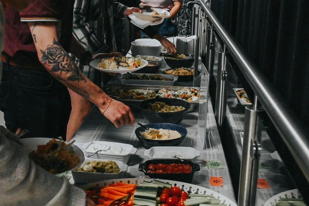 Conference attendees enjoying a buffet of cold and hot food