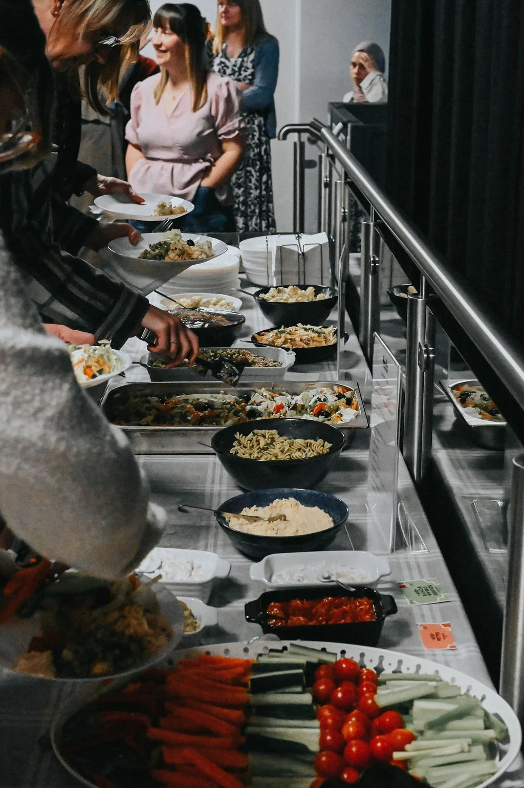 Conference attendees enjoying a buffet of cold and hot food
