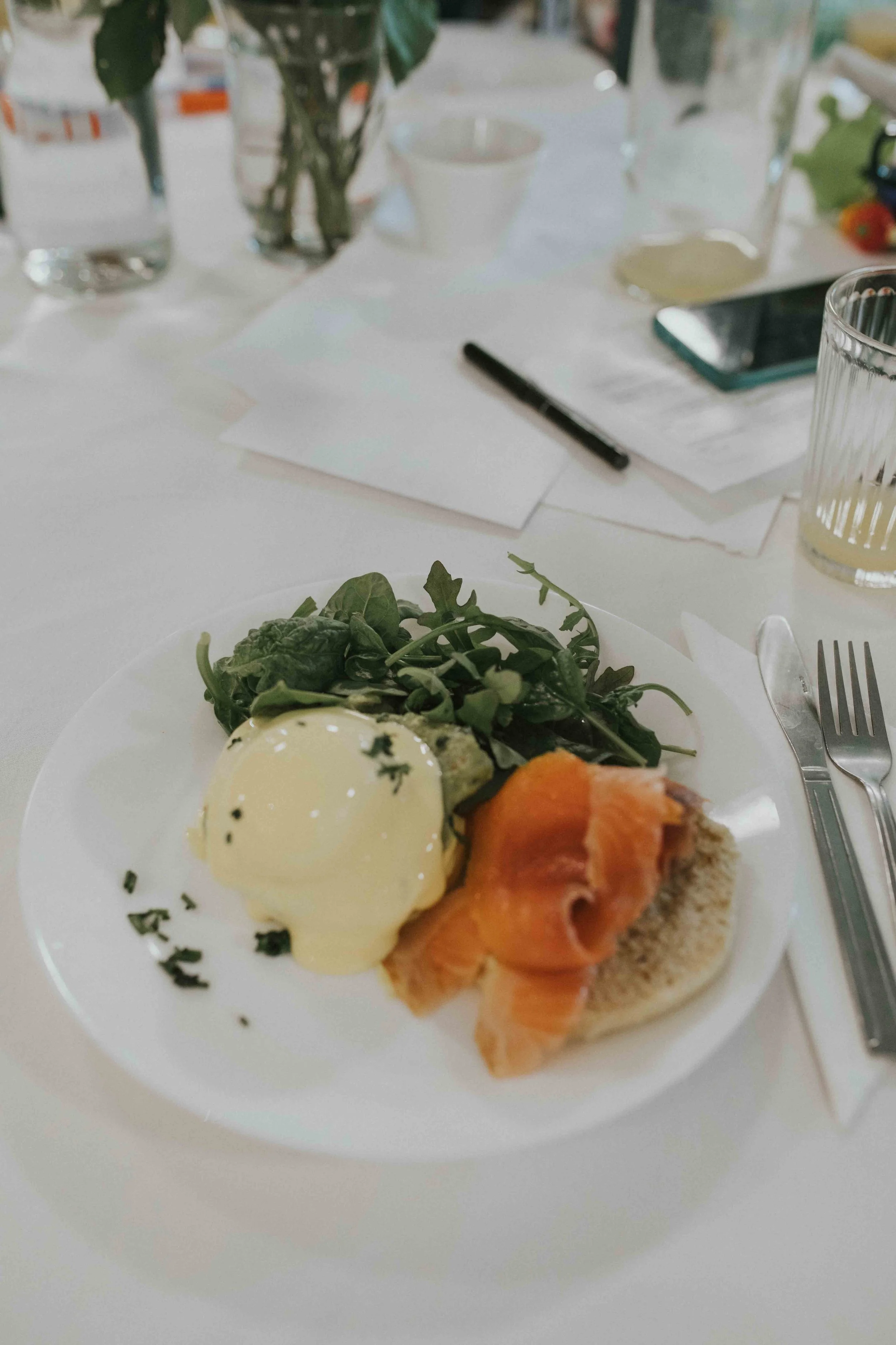 Eggs benedict on a set table with white linen