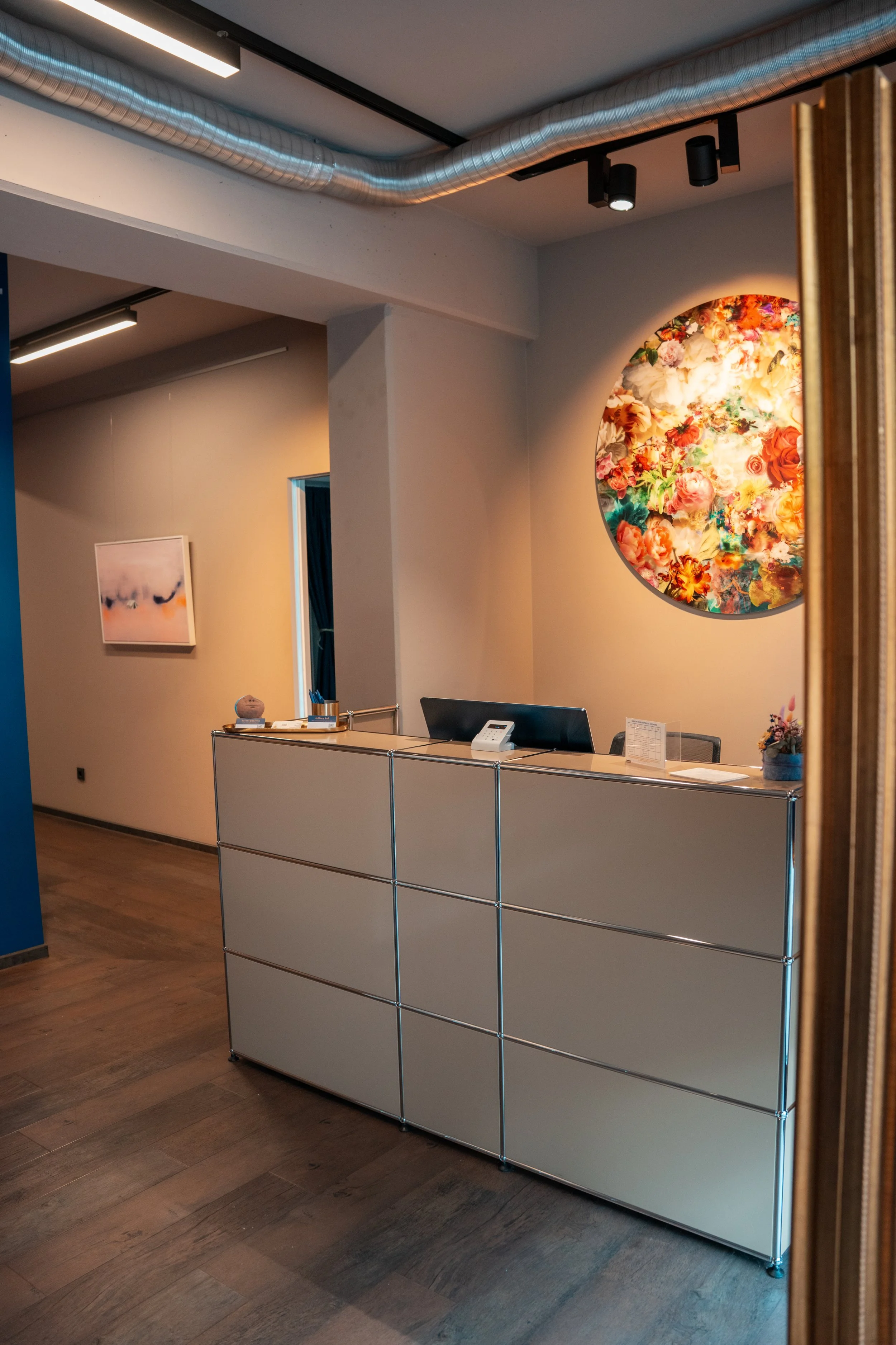 Empfangstresen in einem modernen Kunstgalerie mit abstrakten Kunstwerken an den Wänden.