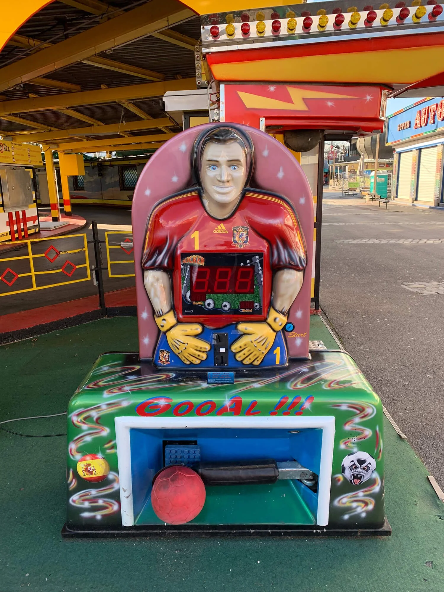Kickerspielautomat mit einem maskottchenhaften Charakter, das ein Fußballtor schießt. Der Automat ist bunt gestaltet mit Spielernamen und dem Wort 'GOAL'.