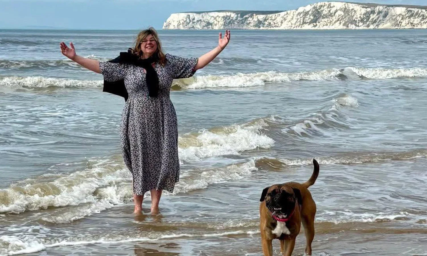 woman-walking-on-beach-with-her-dog