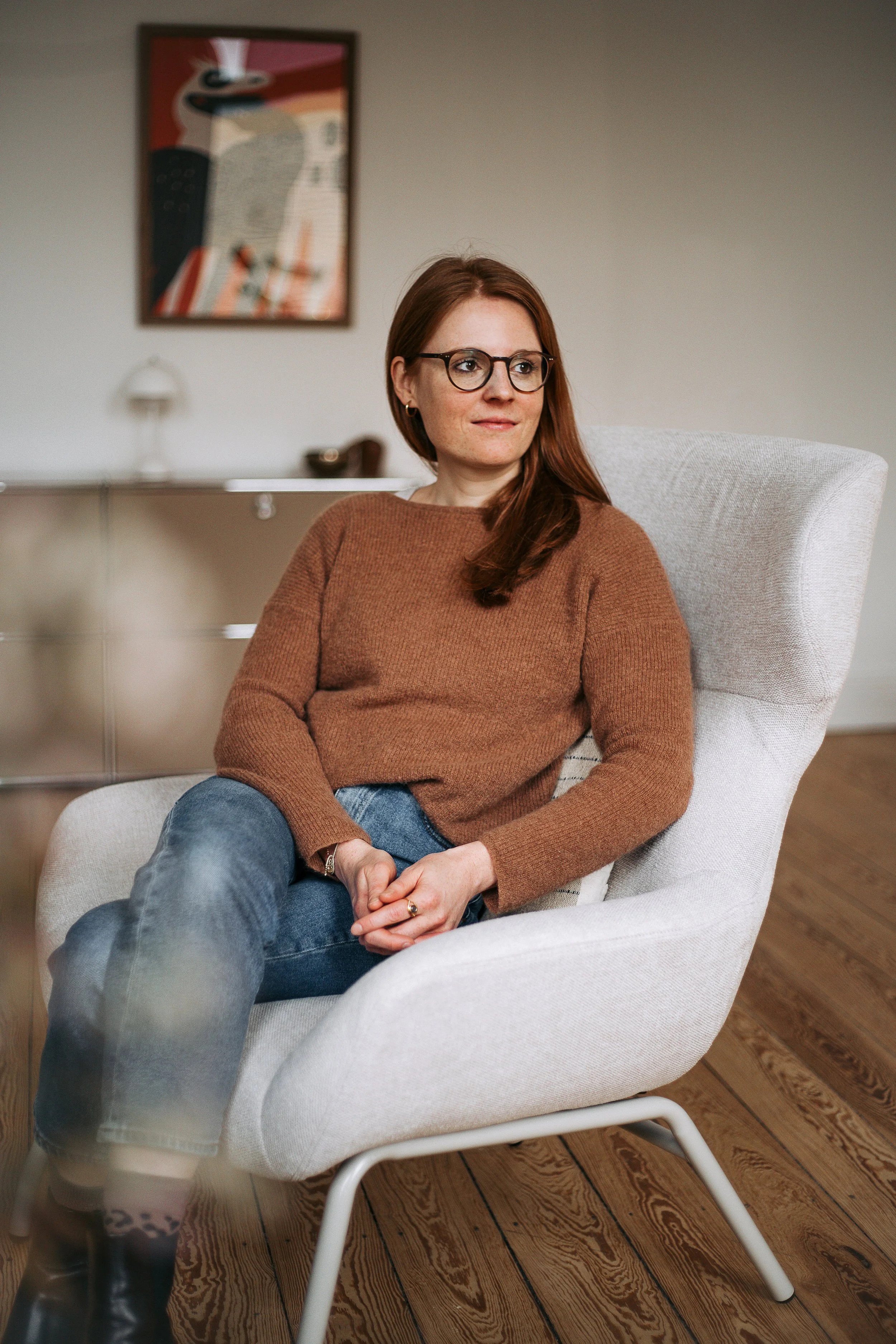 M. Sc. Psych. Luise Popp Psychologische Psychotherapeutin, Psychoonkologin & Yogalehrerin sitzend im Hamburger Praxisraum