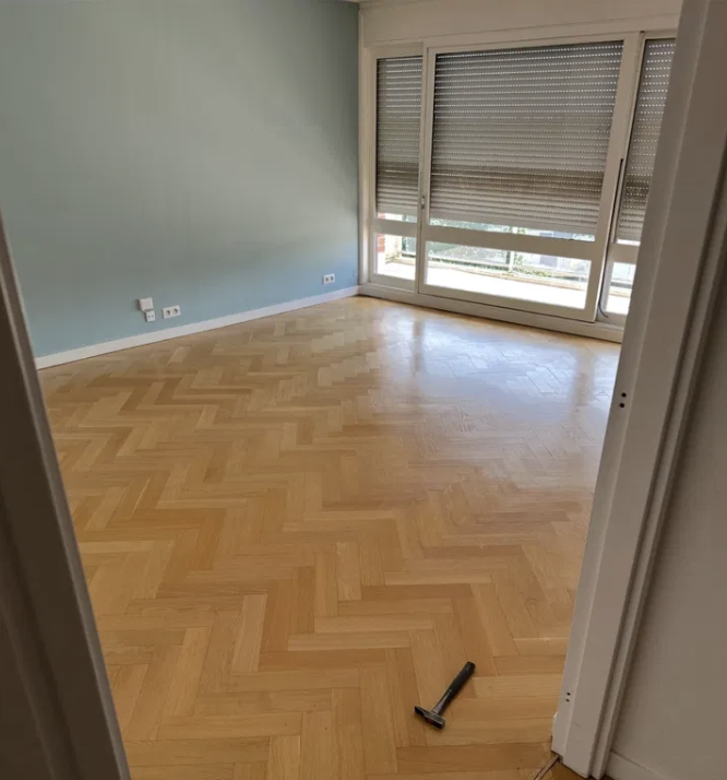 Parquet chêne clair en chevrons posé dans une chambre rénovée