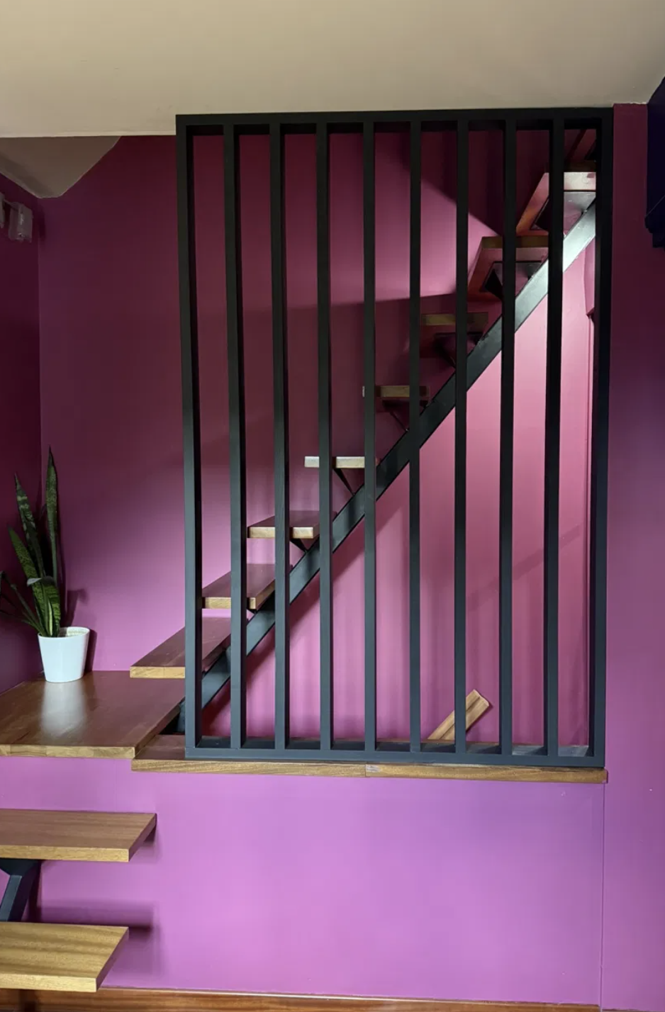 Garde-corps en métal noir posé le long d'un escalier en bois