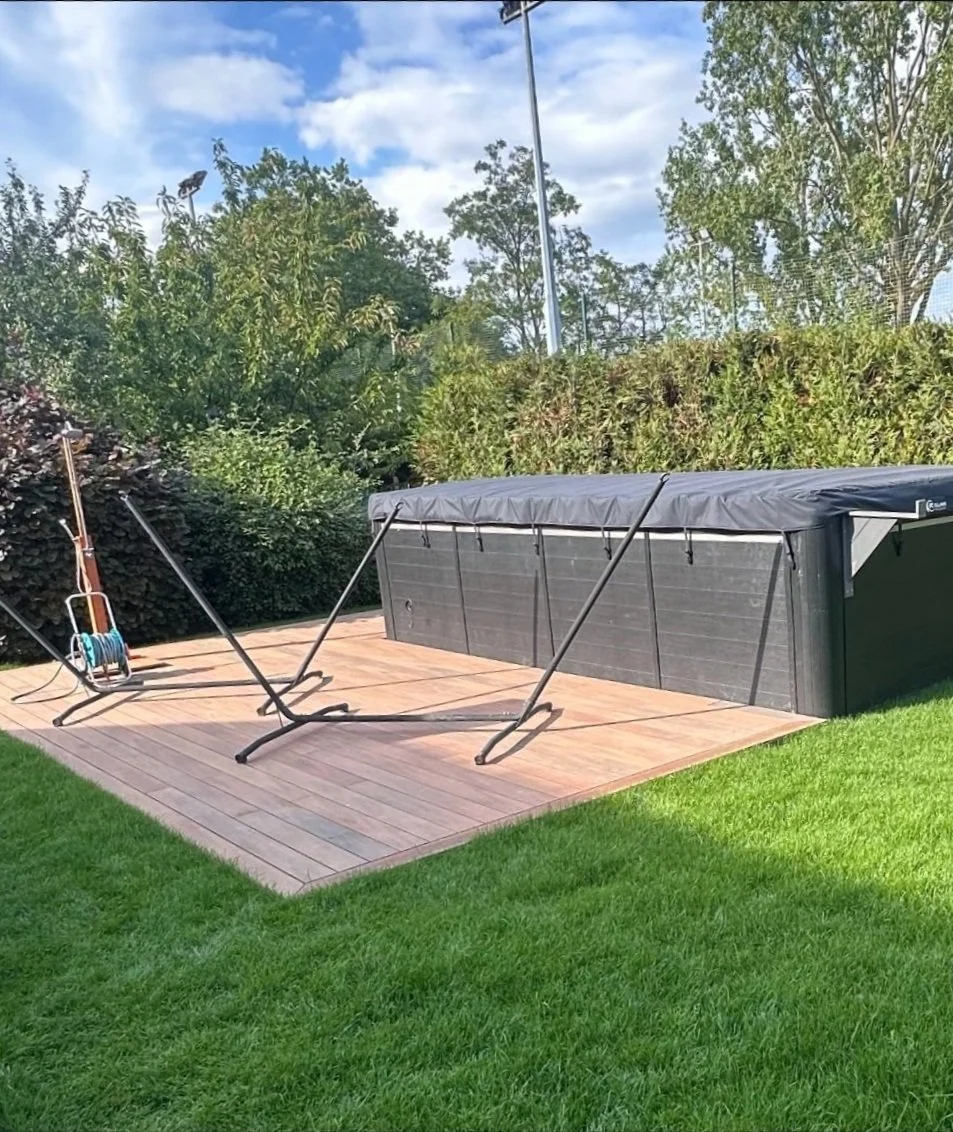 Terrasse en bois sur-mesure aménagée autour d'un spa dans un jardin