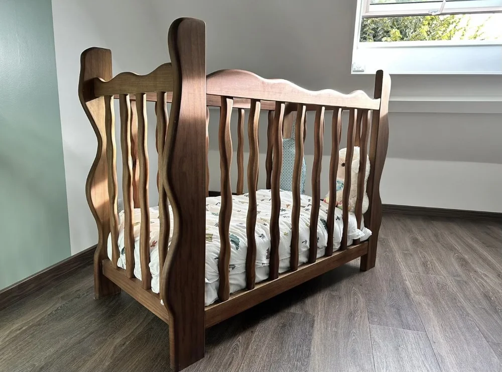 Lit bébé en bois massif aux barreaux sculptés, pièce unique sur-mesure