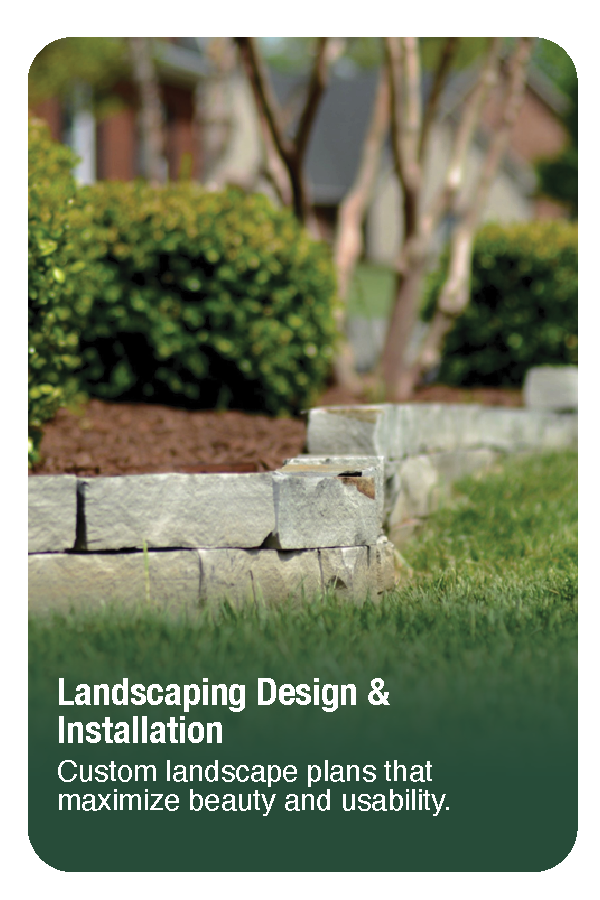 A landscaped yard with a stone retaining wall, green grass, and trimmed bushes, with trees and a house in the background.