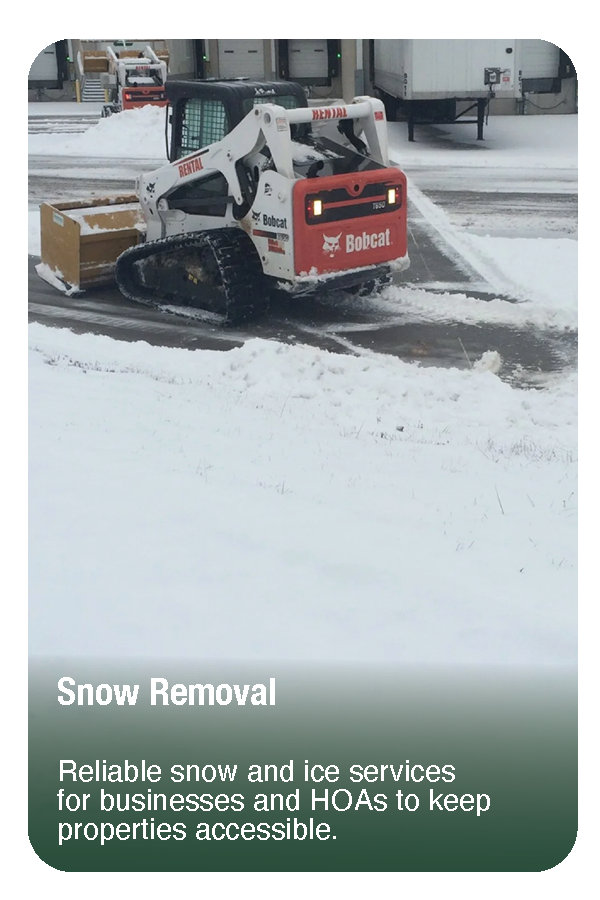 A Bobcat skid-steer loader clearing snow from a parking lot during winter.