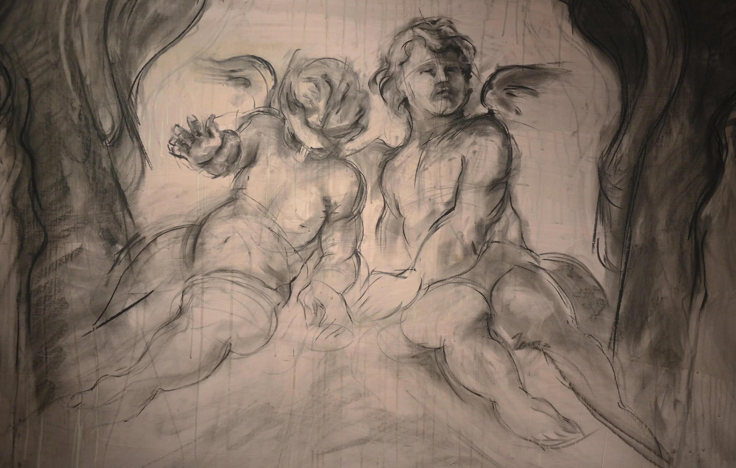 Charcoal drawing of two cherubs with wings, one holding a rose-headed figure, set against a softly shaded background.