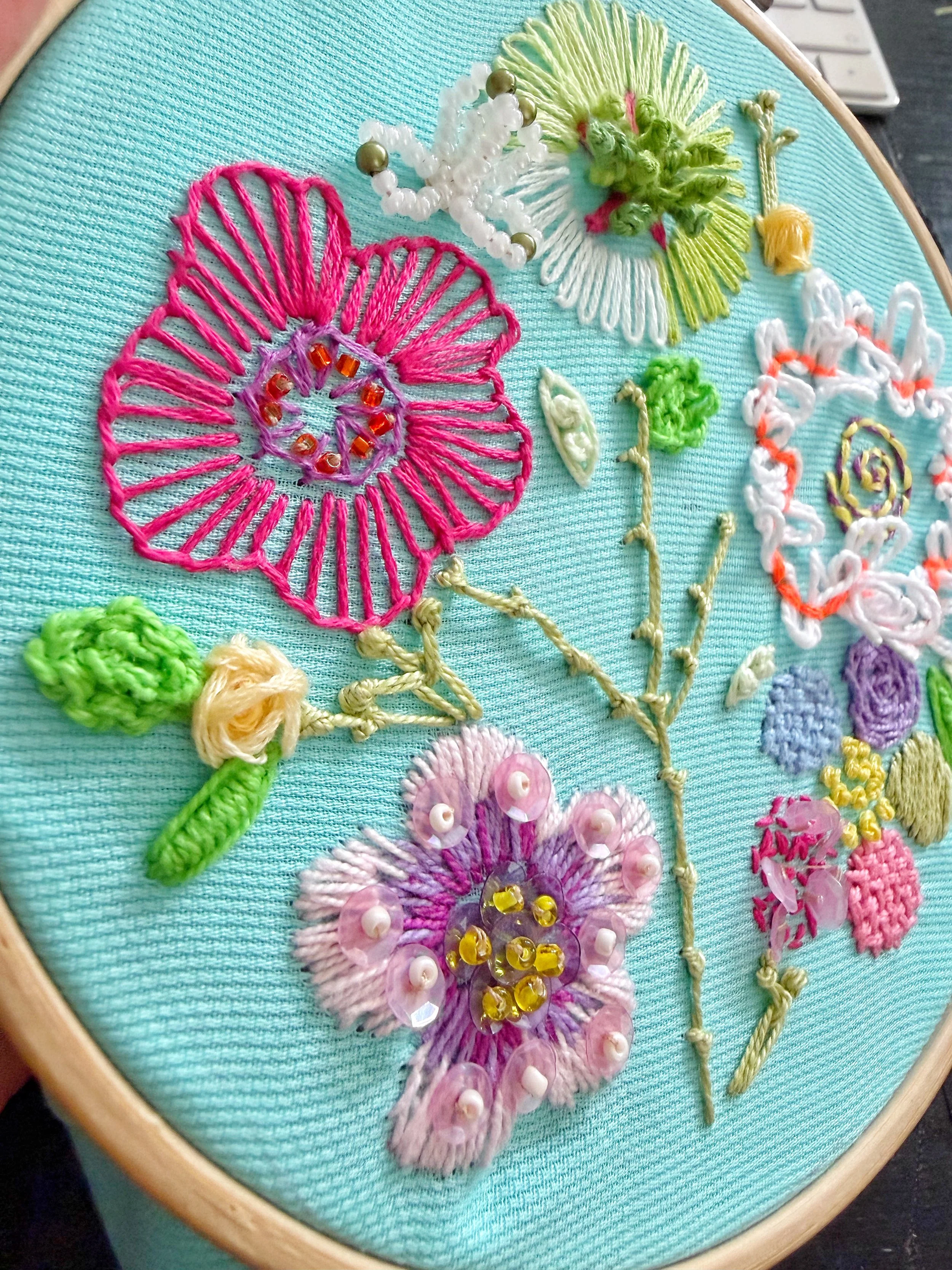 telaio da ricamo con fiori multicolore realizzati con filati, perline e paillettes
