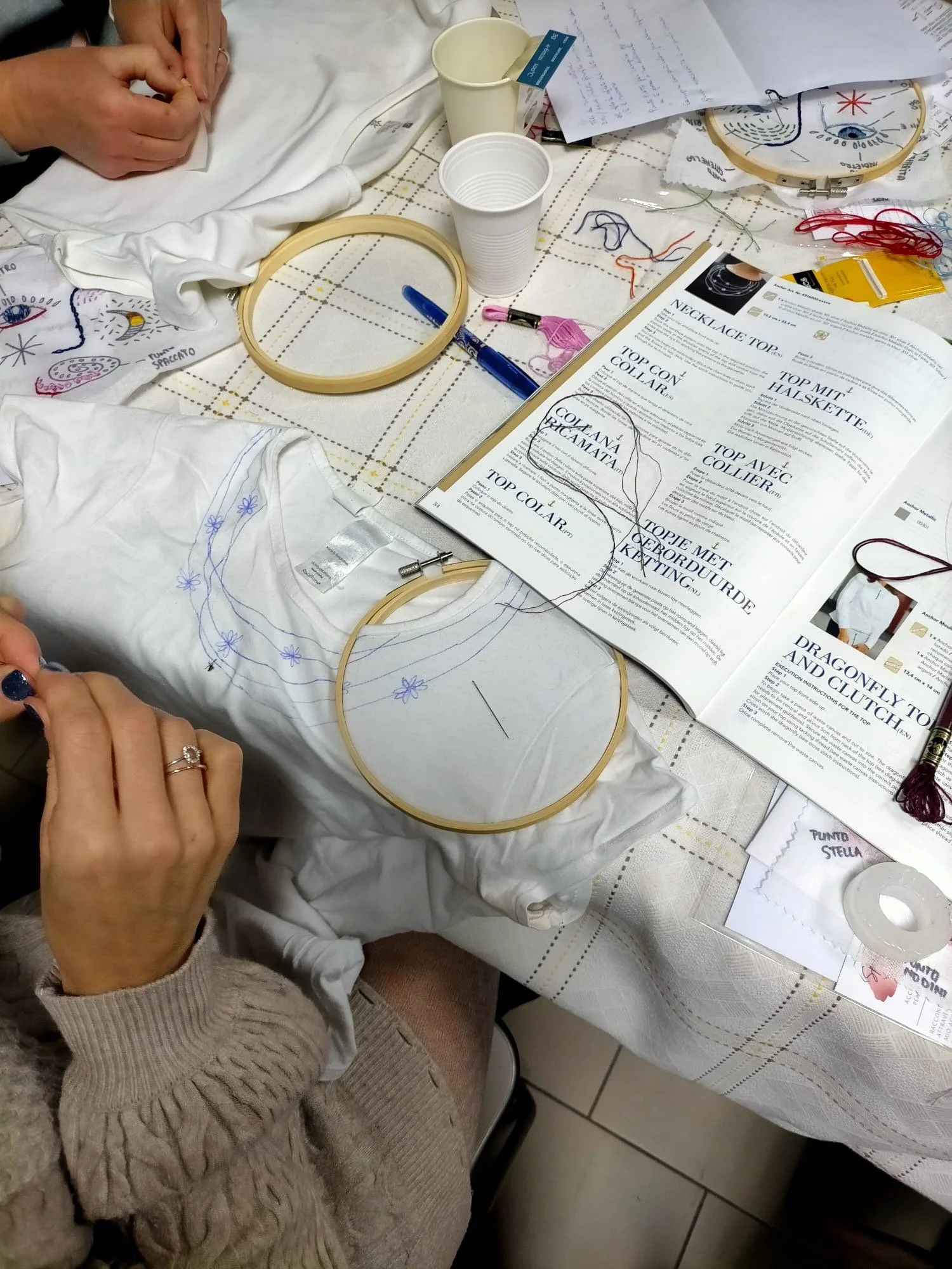 Maglia semplice trasformata con ricamo decorativo fatto a mano durante un incontro del Club del ricamo