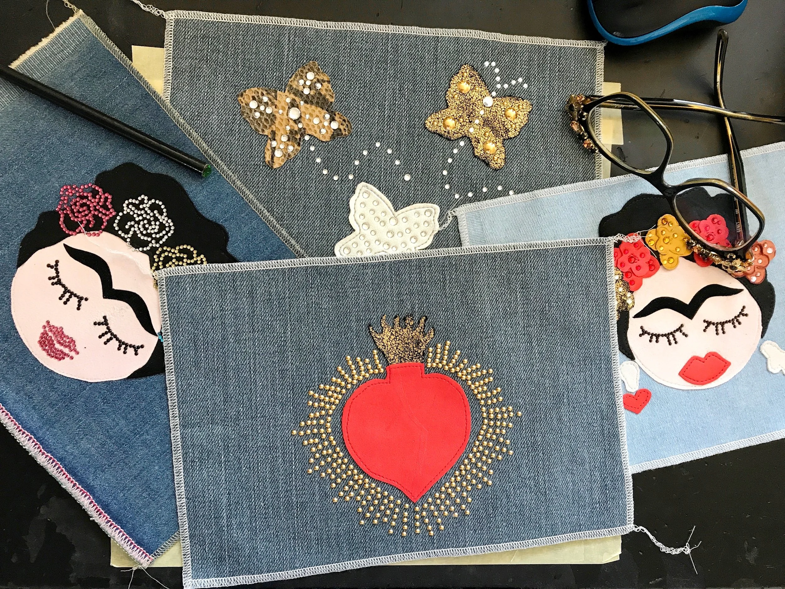 Assortimento di teli in denim decorati con applicazioni in pelle ed ecopelle, impreziositi con strass swarovski e borchie termoadesive