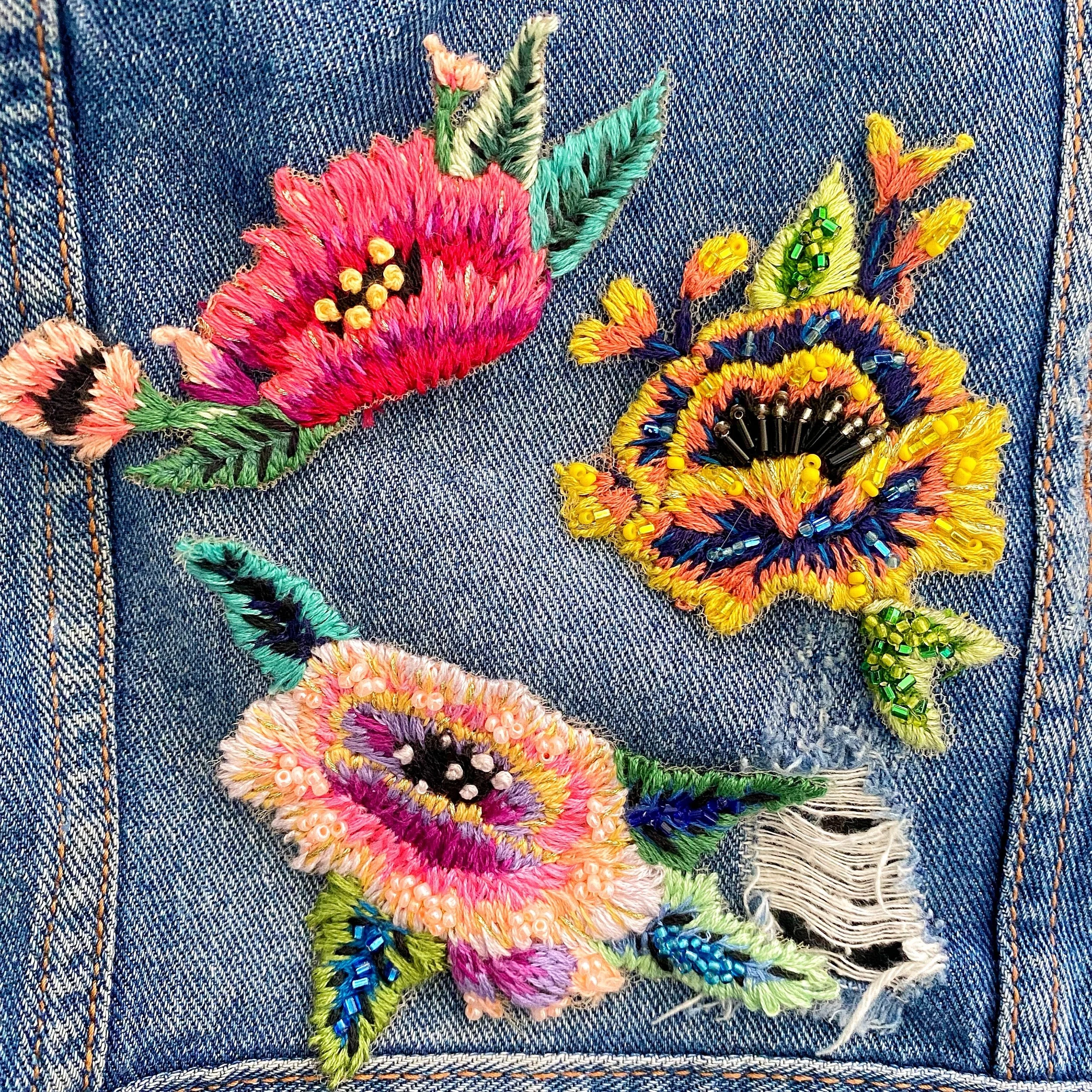 ricami floreali colorati su tessuto denim