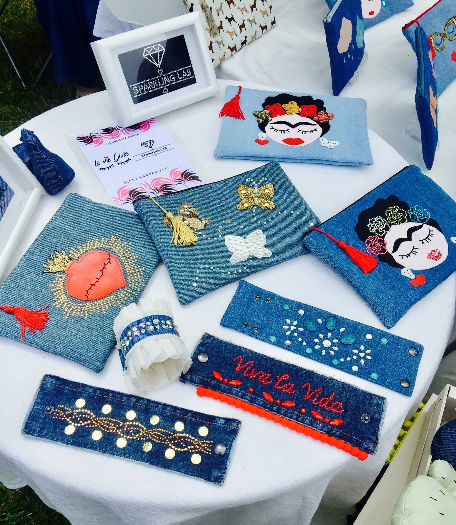 Pochette e bracciali denim di recupero decorati con strass e borchie termoadesive, realizzati per una collezione in collaborazione