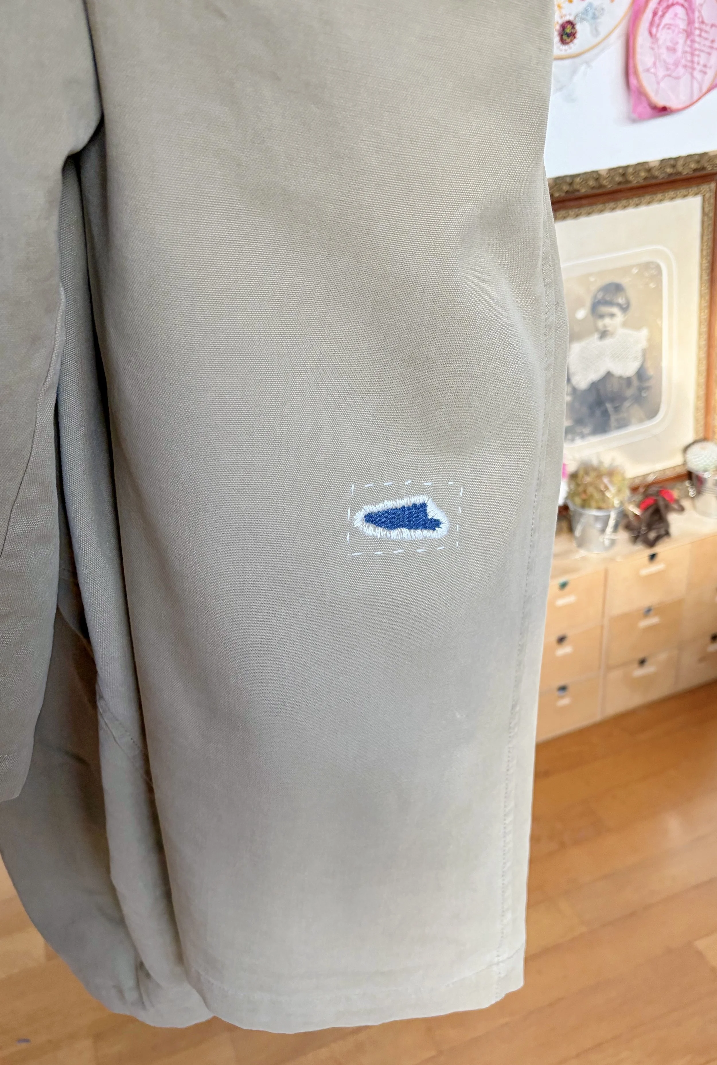 Riparazione di un impermeabile vintage con toppa interna in denim realizzata con tecnica di visibile mending