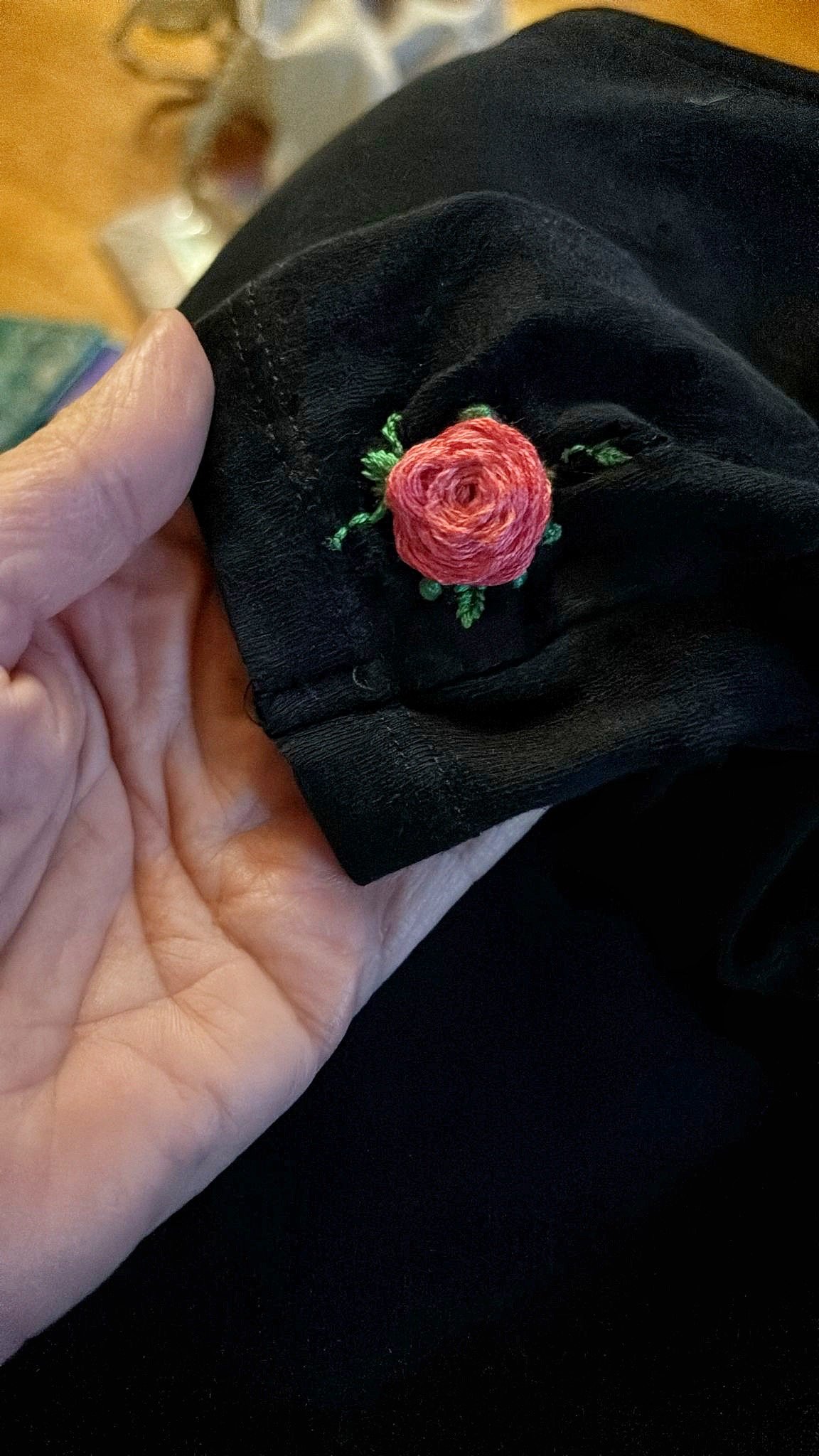 Riparazione creativa di un buco sulla manica di una maglia con un ricamo decorativo
