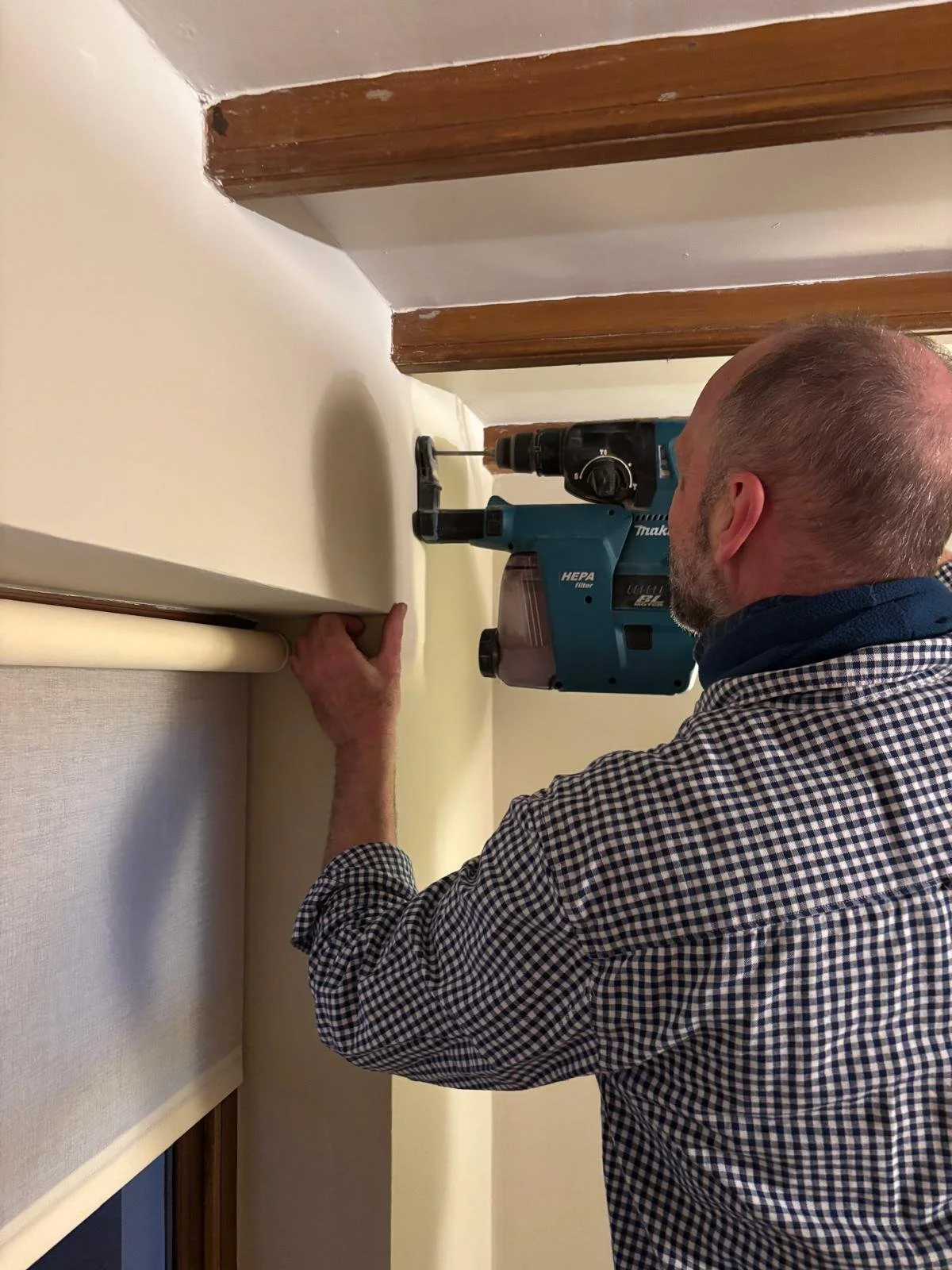 Blind fitter in York uses power tools to install a track before fitting a blind.