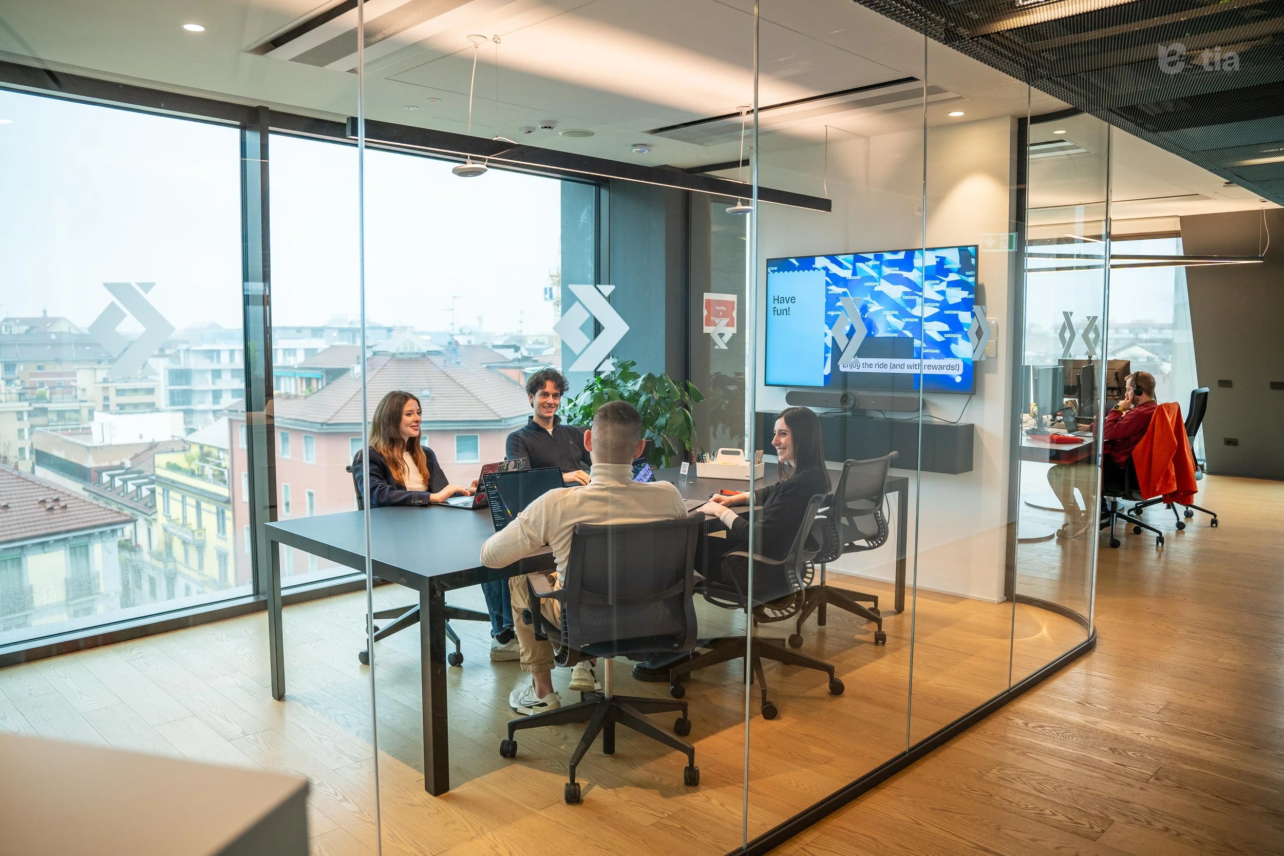 Gruppo di persone che lavora in una sala riunioni moderna con una grande finestra panoramica