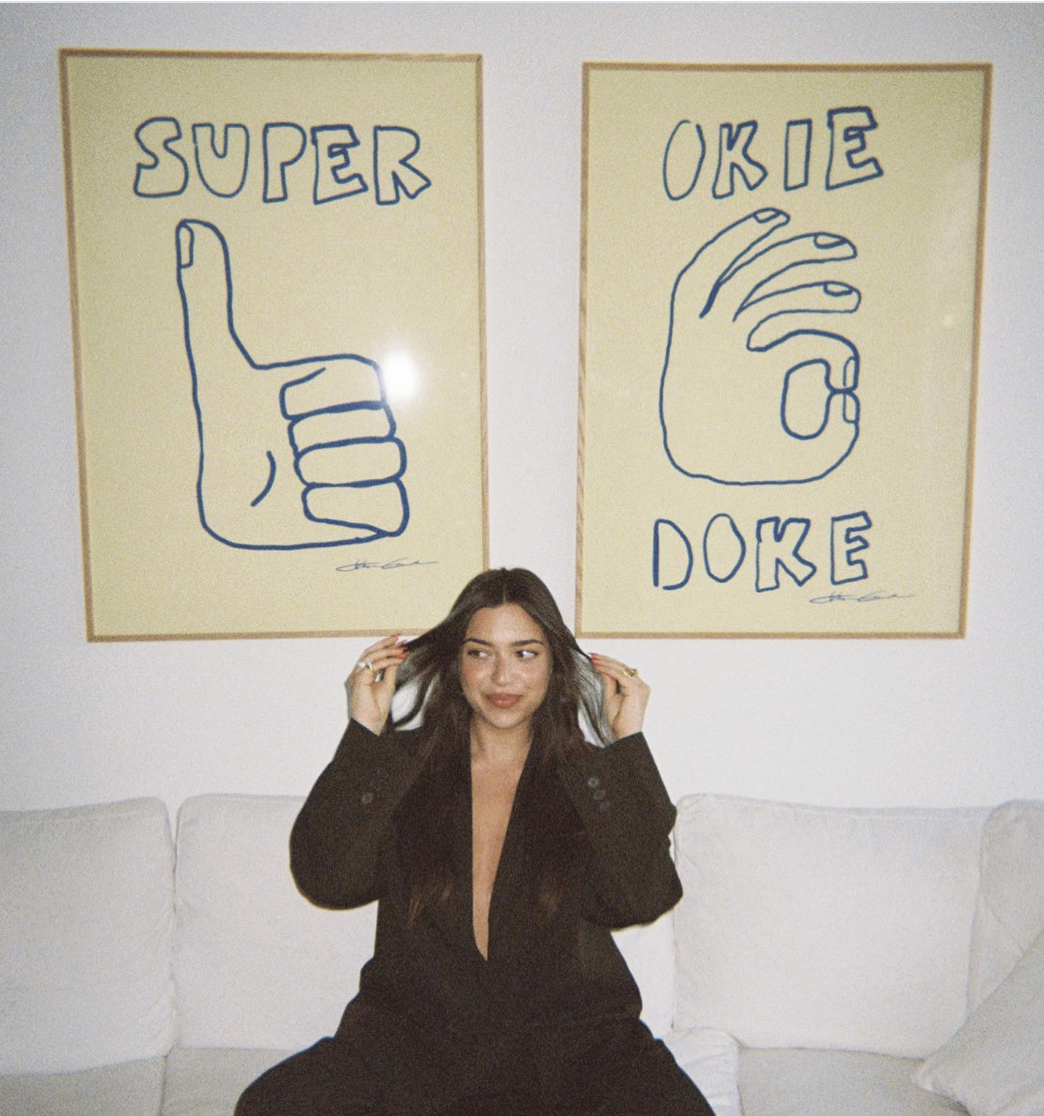 Influencer sitting in front of 2 styled art prints by Stephie Cardona for KunstbyStephie