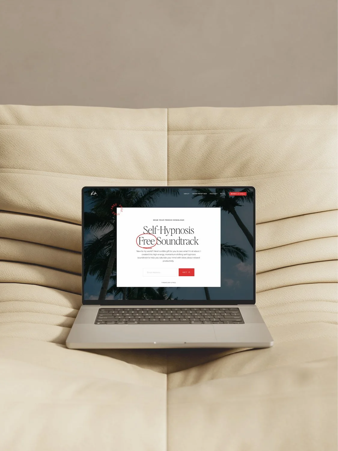 mock up of a website on a laptop, sitting on a padded beige chair
