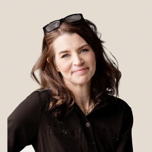 business woman wearing navy jacket with glasses on head