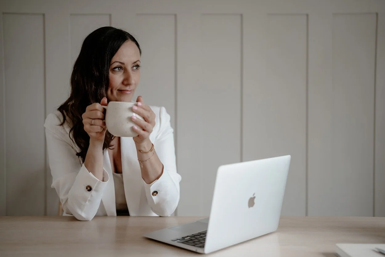 squarespace website designer Clare Butler at desk drinking a coffee in a white mug