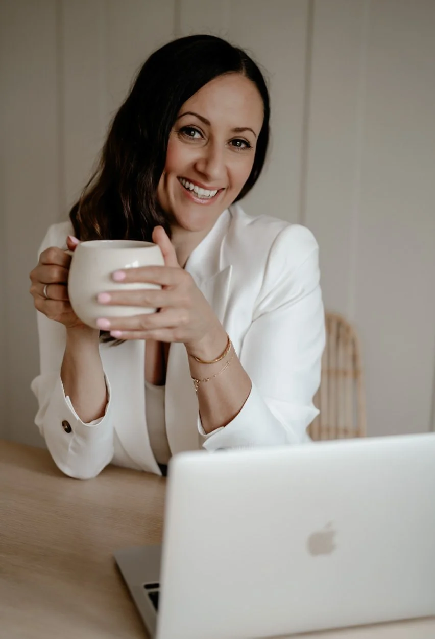 squarespace website designer Clare Butler at desk drinking a coffee in a white mug