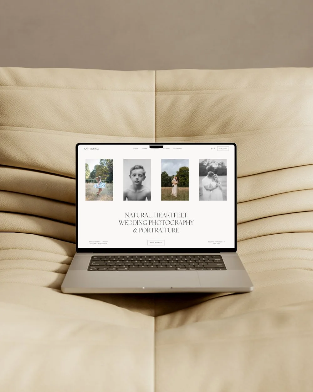 Laptop mock up of a Squarespace website for a wedding photographer on a cream padded sofa