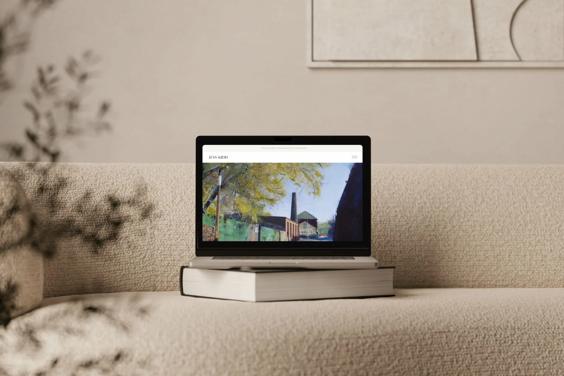 squarespace website for an artist on a laptop mock up on stylish beige sofa scene