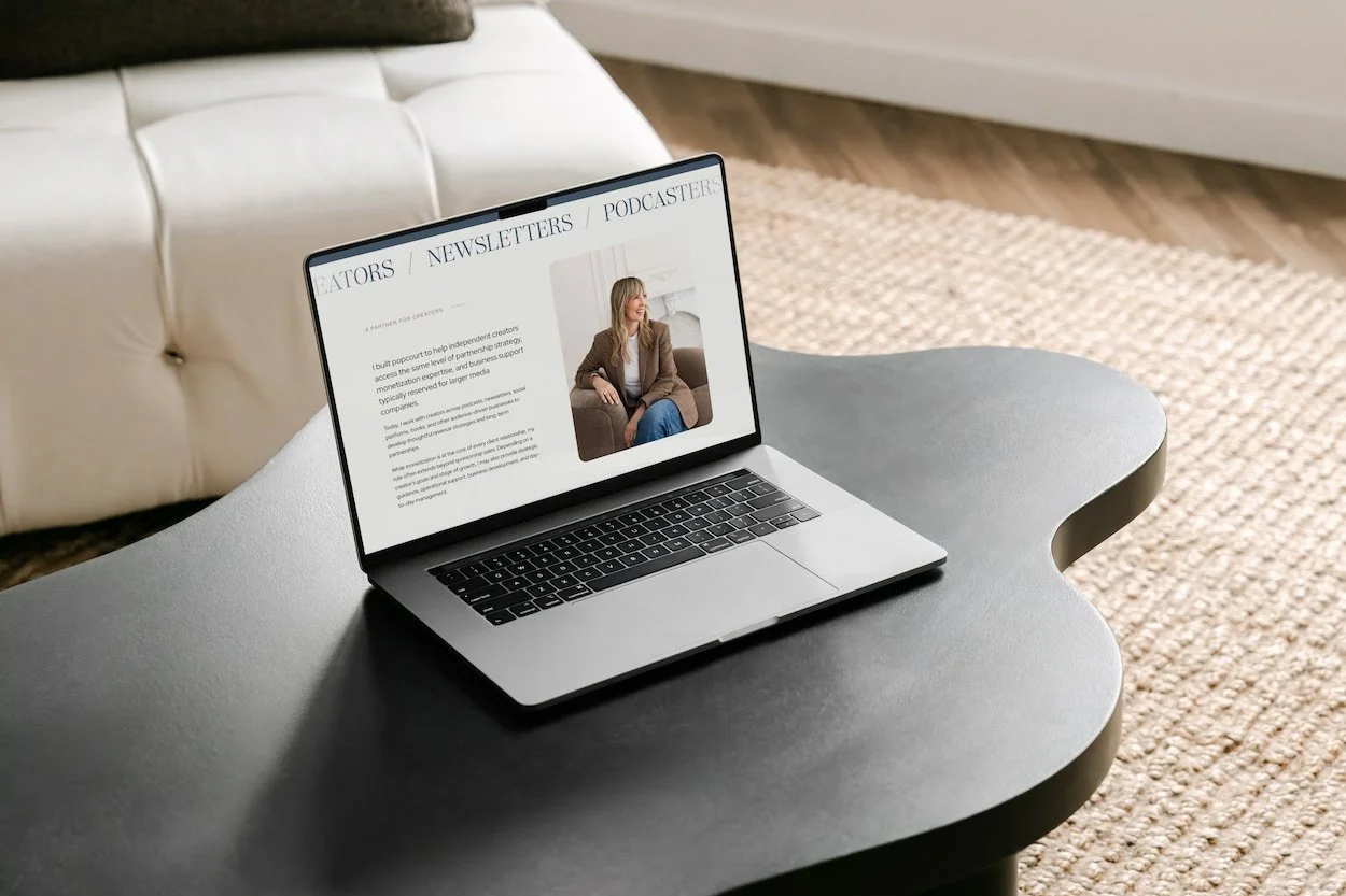 laptop showing a neutral laptop on a black curved coffee table
